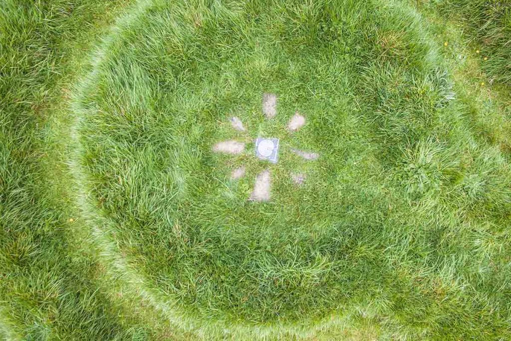 celtic-spiral-stone-circle-ireland Aerial perspective of an ancient Celtic spiral stone circle design in the green grass