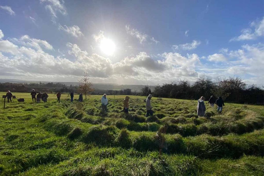 group-meditation-walking-labyrinth-limerick A group of people mindfully walking the grass labyrinth during a spiritual nature retreat