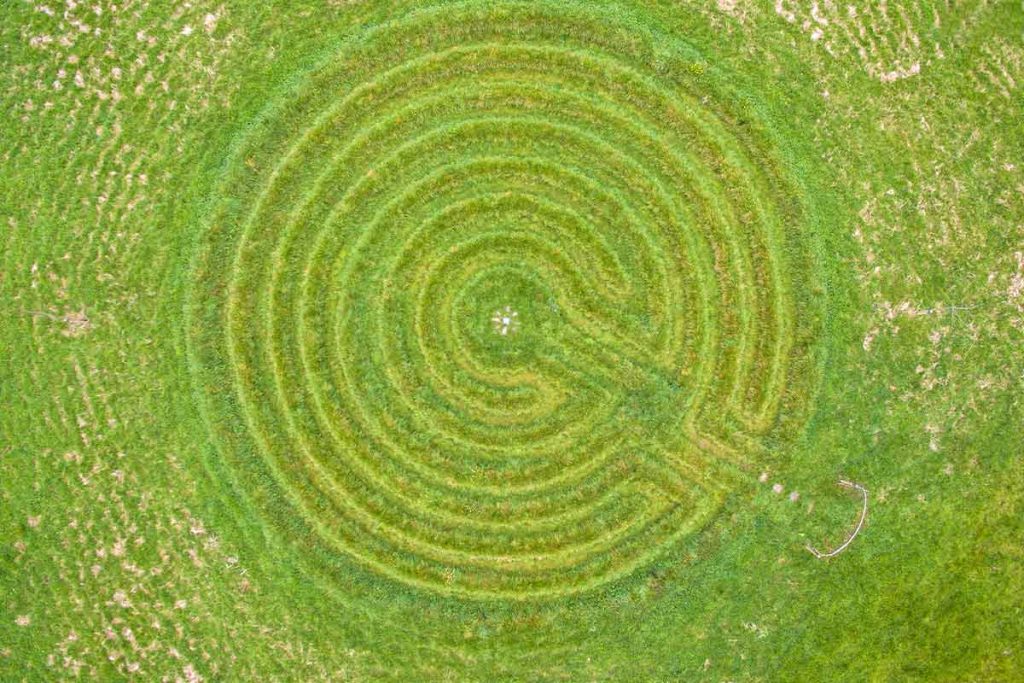 sacred-geometry-grass-labyrinth-limerick Perfect top-down drone shot of the intricate concentric grass labyrinth circles