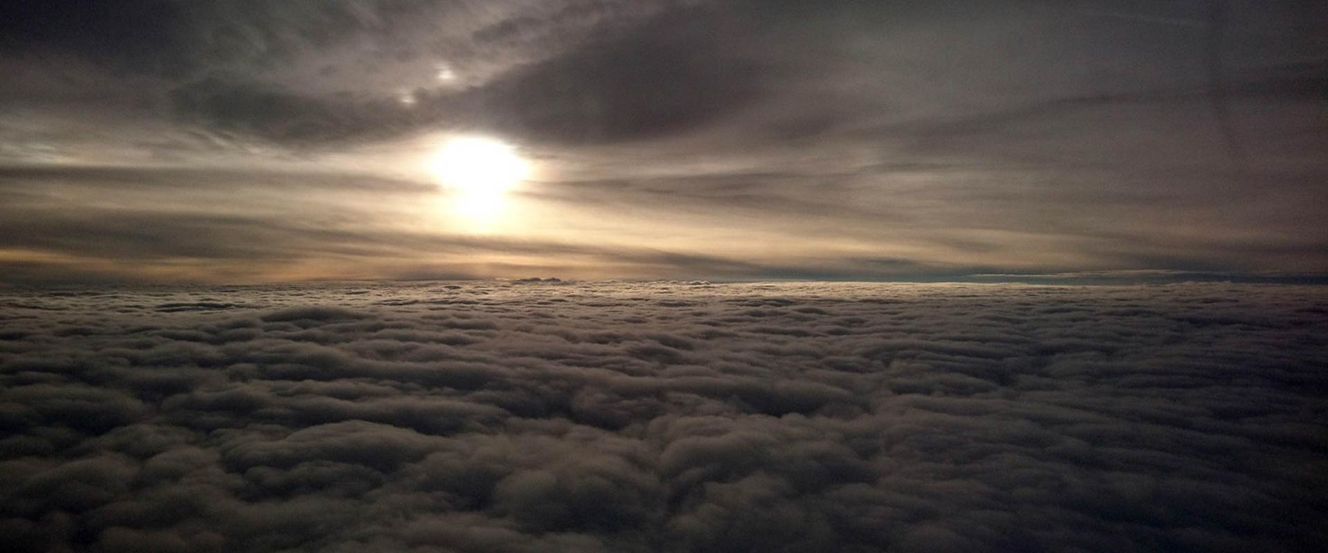 Dramatic sunrise shining brightly over a thick bed of clouds from an aerial perspective in Ireland
